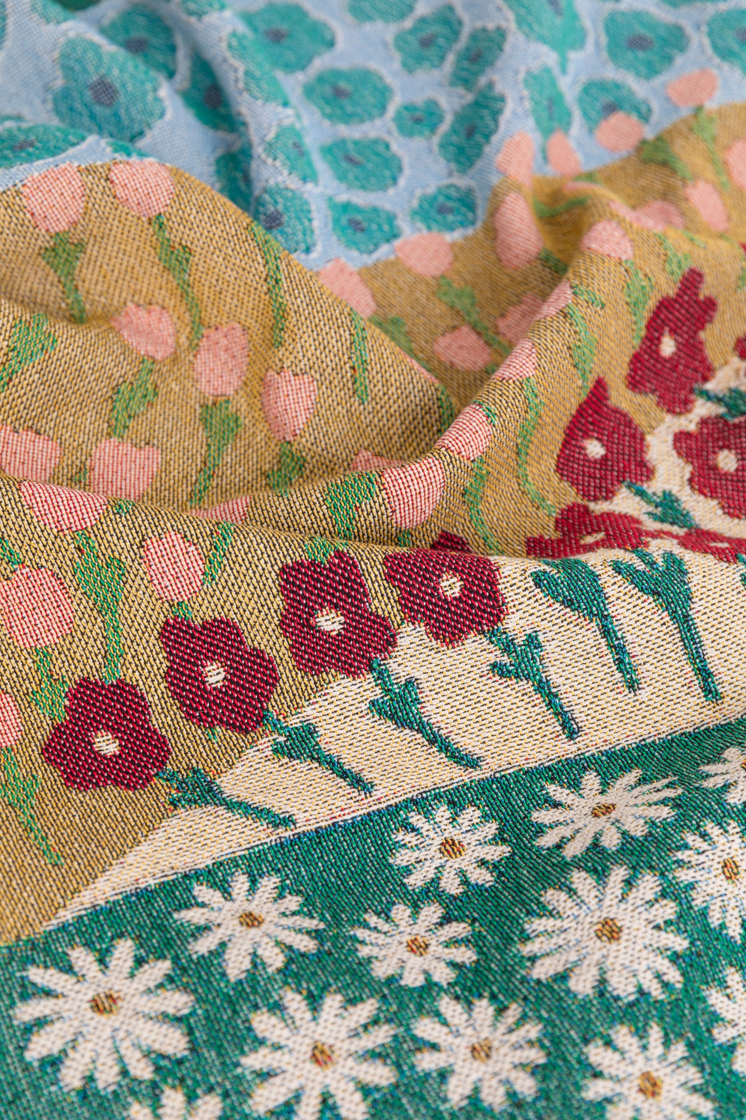 Colorful woven throw blanket with a floral pattern and geometric designs