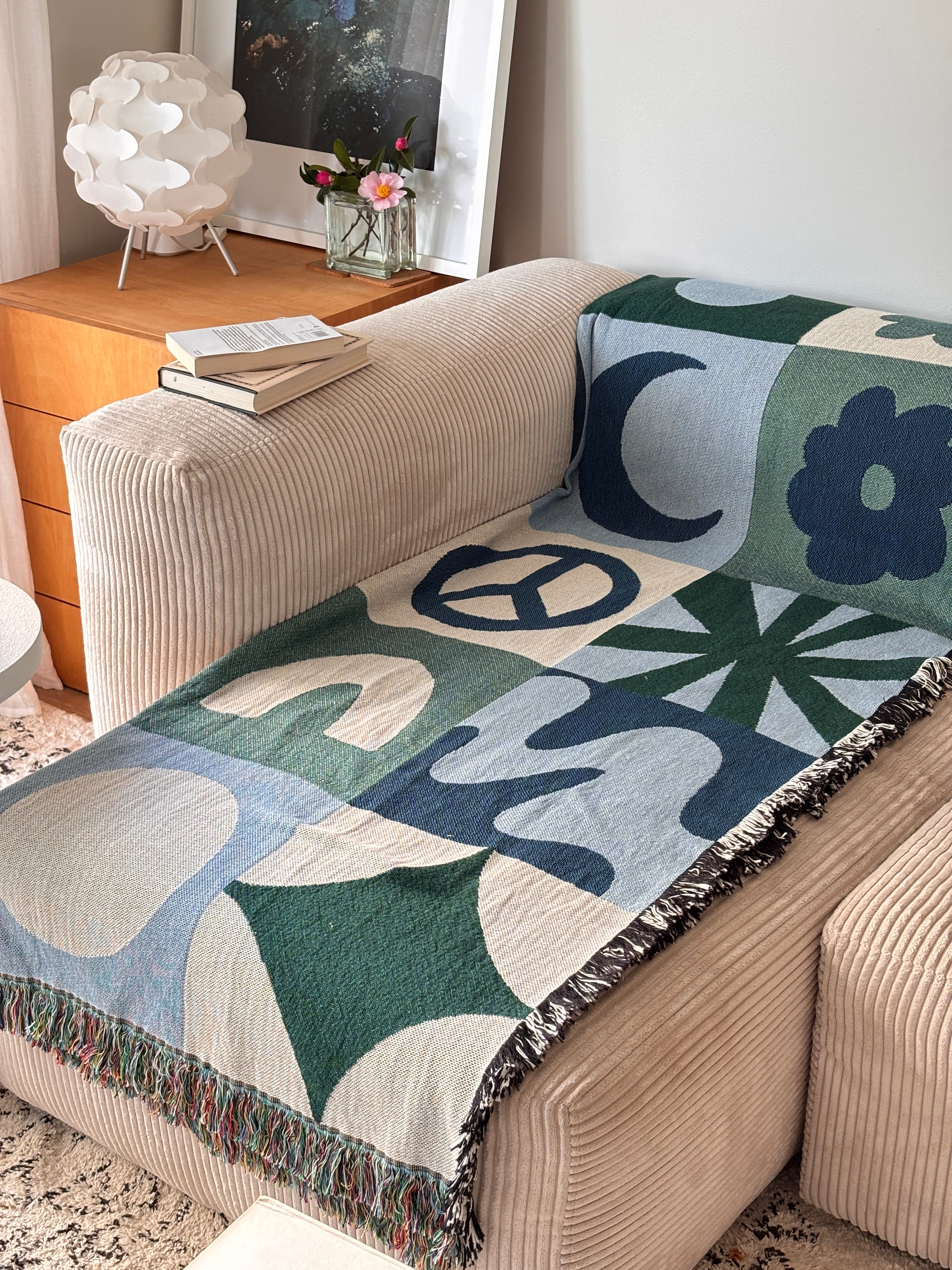 Geometric throw blanket with abstract patterns draped over a couch in a living room.