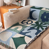 Geometric throw blanket with abstract patterns draped over a couch in a living room.